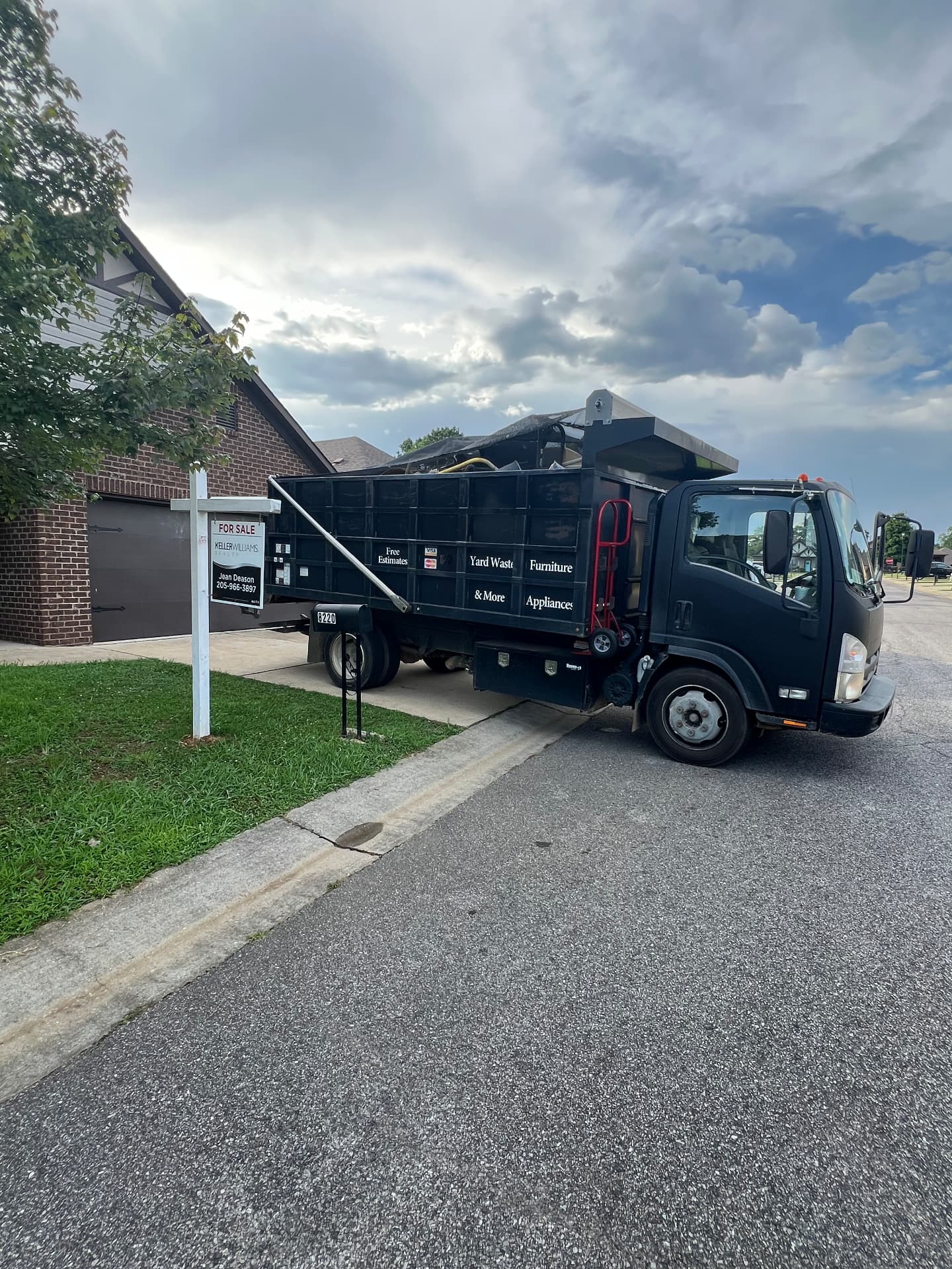 Ross's Junk Removal dump truck parked in a residential driveway during a cleanout